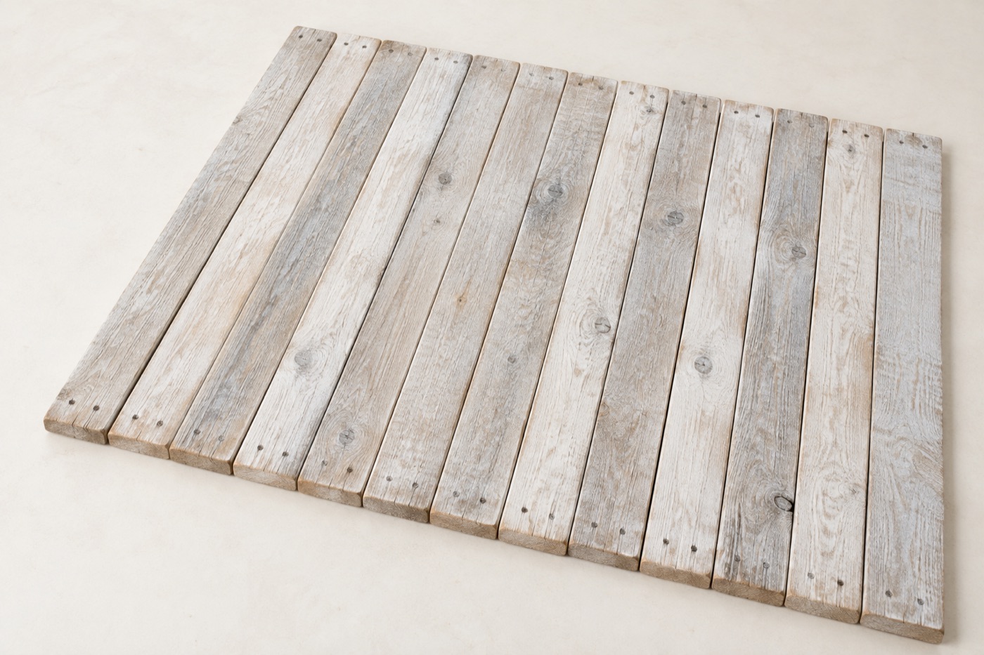 Whitewashed reclaimed wood boards with a chalky white finish and grain showing through